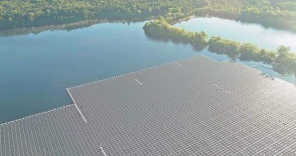 Vista aérea do sistema de plataforma celular de painéis solares flutuantes em uma lagoa azul sob a luz solar. — Vídeo de Stock