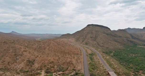 Vista aérea aventura viajando por carretera desértica de la carretera asfaltada a través de las áridas montañas del desierto de Arizona — Vídeos de Stock