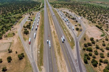 Panoramic aerial horizontal view of rest area truck stop on the car parking endless Interstate highway in desert Arizona USA clipart