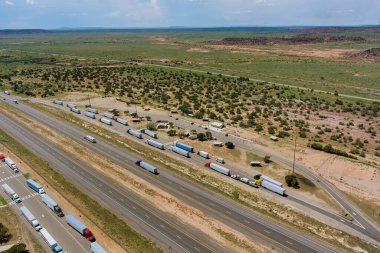 Aerial horizontal view of rest truck stop area near endless Interstate highway in desert Arizona clipart