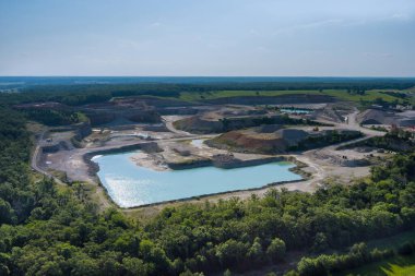 Mavi gölde açık çukur kazılı maden ocağı havadan bakıldığında madencilik faaliyetlerinin oluşturduğu bir yer.