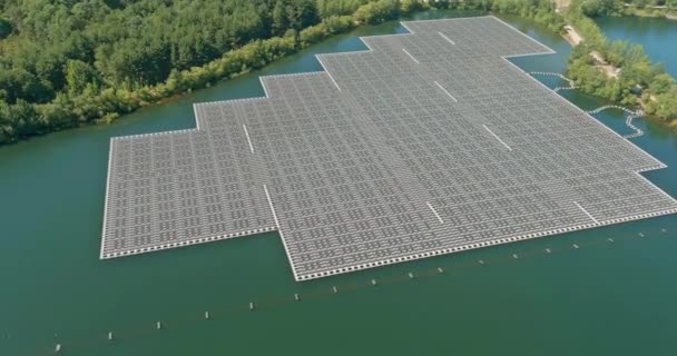 Vista aérea do sistema de plataforma celular de painéis solares flutuantes em uma lagoa azul — Vídeo de Stock