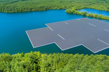Panorama aerial view of renewable alternative electricity energy the floating solar panels cell platform on the beautiful lake clipart