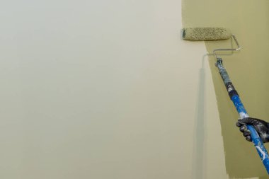 Apartment renovation the worker painting apartment wall on surface wall by roller brush