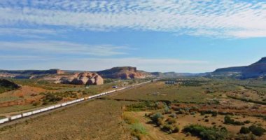 Aerial views over train going through dry lands in a desert New Mexico USA