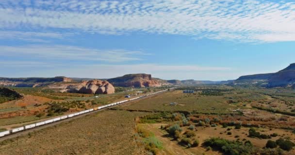 Aerial views over train going through dry lands in a desert New Mexico USA — Αρχείο Βίντεο