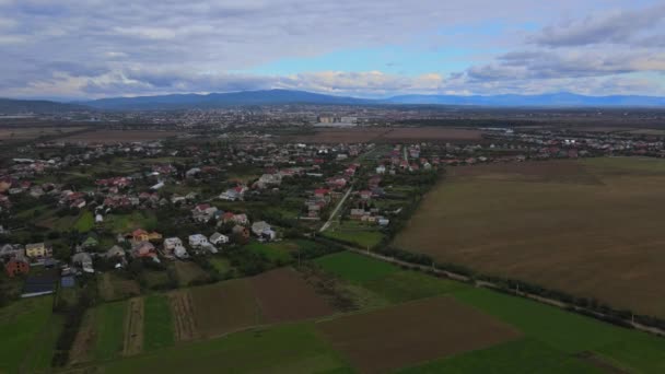 Vista aérea com casas e ruas em campos arados, prados bonitos de aldeia rural — Vídeo de Stock