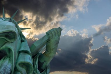 Manhattan 'da güzel turuncu gökyüzü günbatımına sahip Özgürlük Heykeli.