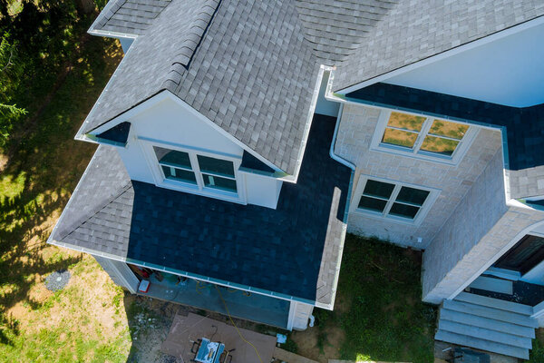 Rooftop in a new home constructed showing asphalt shingles multiple roof lines with aerial view