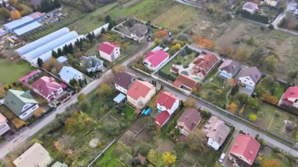 Belle vue aérienne depuis la hauteur du village rural avec maisons et rues, champs labourés, prairies — Video