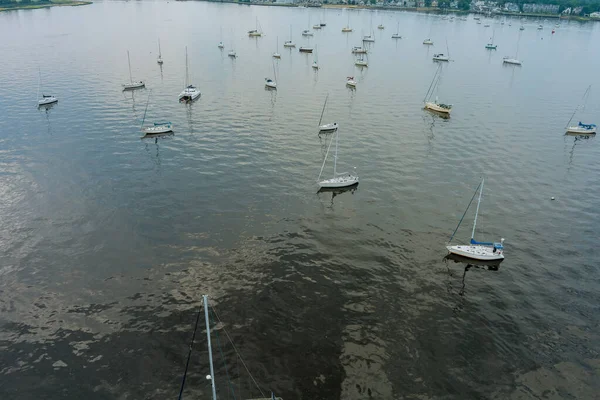 Güneşli bir havada direklerle yüzen bir çok yatın havadan görüntüsü.
