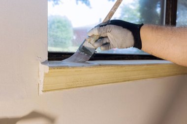 Tamircide pencere pervazı çerçevesi boyuyor.