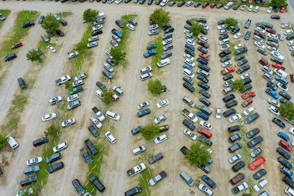 Top aerial view of auto auction many used car lot parked distributed in a parking.