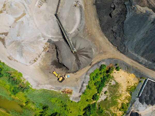Aerial view of open cast mining panorama quarry with lots at work of machinery equipment at a quarries