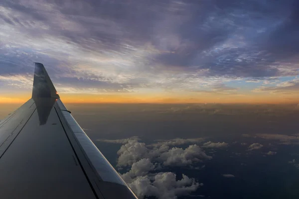 ふわふわの雲の中で素晴らしい夕日で飛行中の飛行機の翼 — ストック写真