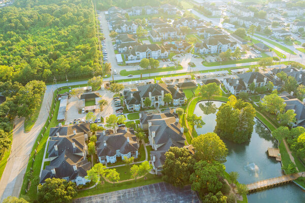 Above Houston , Texas suburb area west of downtown with morning golden hour sunlight aerial view