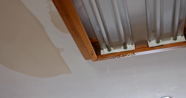 Água que corre do dispositivo elétrico da luz do teto devido à tubulação de água da explosão — Vídeo de Stock