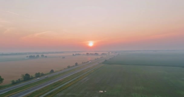 La hora dorada, mañana brumosa con el sol naranja saliendo detrás del prado cubierto de densa niebla — Vídeos de Stock