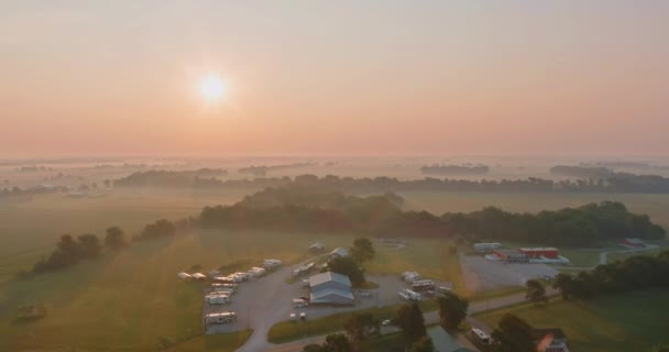 在春雾弥漫的早晨，日出时分的乡村风景，田野中的道路 — 图库视频影像