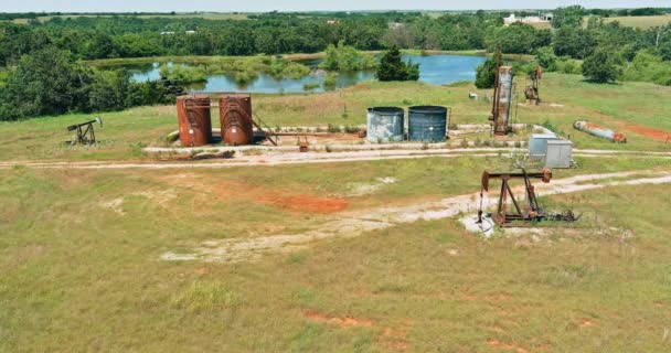 Um macaco de bomba de poço de petróleo bombeando petróleo cru um de Oklahoma um dia ensolarado — Vídeo de Stock