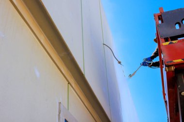 Müteahhit asansörden çıkıp binanın dış cephesini sprey boyayla boyamış..