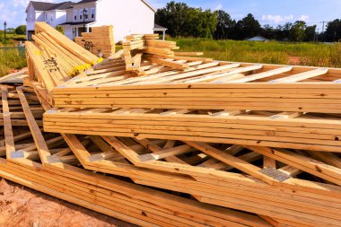 Yığılmış ahşap kirişler, müşterek inşaat malzemeleri. İnşaat sahasında çerçeve altında oturuyorlar.