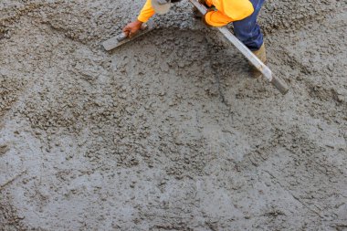 İnşaat işçisi temeli altındaki ıslak betonu ustalıkla döşemiş.