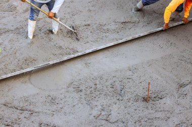 İşçiler beton döşeme sırasında inşaat projesine yeni beton dökme teknikleri uyguluyorlar