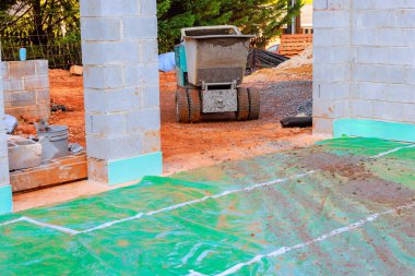 Tekerlekli beton el arabası inşaatı ve çimento temeli kullanan işçiler