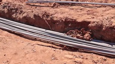 İşçiler inşaat sahasına elektrik tesisatı kuruyor, kamu hizmetleri için zemin hazırlıyorlar.