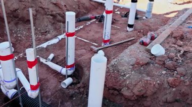 Atık su tesisat boruları iş günü boyunca şantiyenin yeni kazılmış bölgesine yerleştiriliyor.