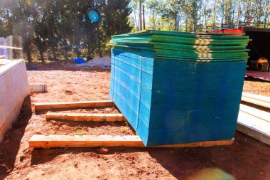 İnşaat alanındaki ahşap kirişlere istiflenmiş tahtalar