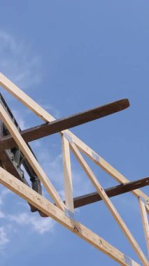 Telekonsor vinç, çerçeve oluşturma işlemi sırasında inşaat alanında ahşap kirişleri kaldırıyor.