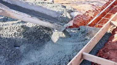 İnşaat alanındaki ahşap çerçevelere taze beton dökülüyor..