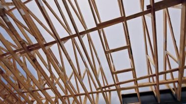 İşçiler inşaata hazırlanırken tahta kirişler çatıyı inşa etmek için karmaşık bir yapı oluşturuyor..