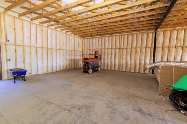 Geniş alanda tamamlanmamış iç mimari çerçeve, yalıtım ve inşaat asansörü.