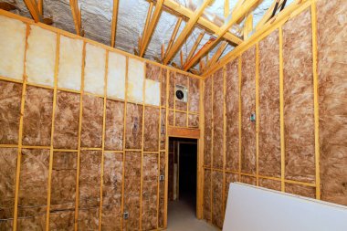 Odalar tadilatın ortasında, inşaat projesinde yalıtım malzemelerini çerçeveleyen kirişler.