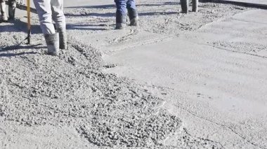 İnşaat işçileri inşaat sahasına ıslak beton döküyorlar.