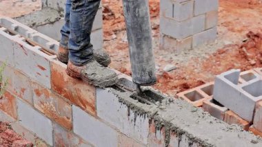 İnşaat işçisi inşaat alanındaki betonu sıkıştırmak için beton pompa kullanıyor..