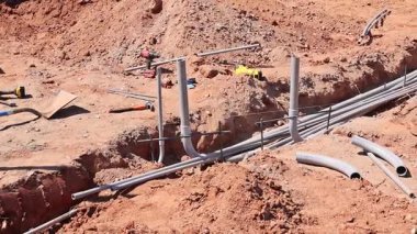 İşçiler inşaat alanındaki hendeğe elektrik boruları döşedi