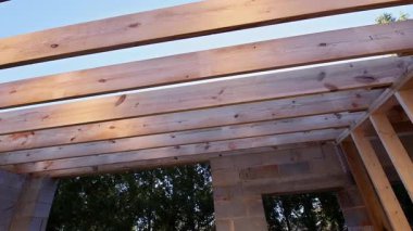 İşçiler, çerçeve inşaatı altındaki iskan alanında ahşap çatı iskeleti inşa ediyorlar