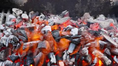 Mangal kömürü kıvılcımları alevleniyor, barbekü şenlikleri sırasında et kızartmaya hazırlanıyor.