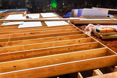 İşçiler inşaat alanını düzgün dizilmiş ahşap kirişlerle hazırlıyorlar.