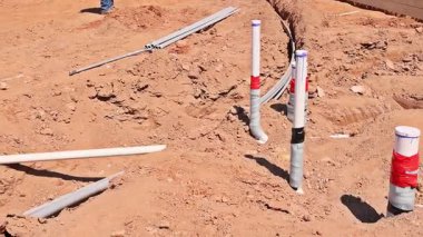 İşçiler inşaat sahasında tesisat hatları kuruyor..