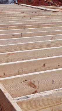 İşçiler inşaat alanını düzgün dizilmiş ahşap kirişlerle hazırlıyorlar.