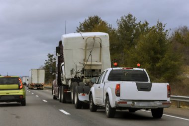 Büyük beyaz kamyonet de dahil olmak üzere birden fazla araç yoğun Amerikan otoyolunda ilerliyor.
