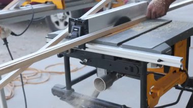 Marangoz, açık hava ortamında ahşap işleri için masa testeresi kullanıyor..