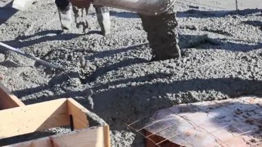 İnşaat işçileri ahşap forma beton döküp yeni bina için sağlam temeller hazırlamakla meşguller..