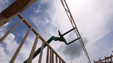 İşçiler, inşaat sırasında çatı kirişlerini yapı iskeletine yerleştirmek için asansör kullanıyorlar