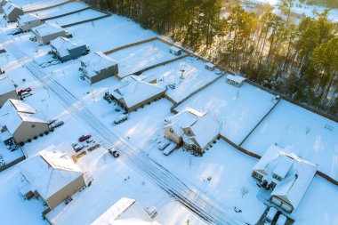 Sabah güneşi karla kaplı mahalleyi aydınlatıyor, Amerikan kasabası huzurlu kış manzarasını..